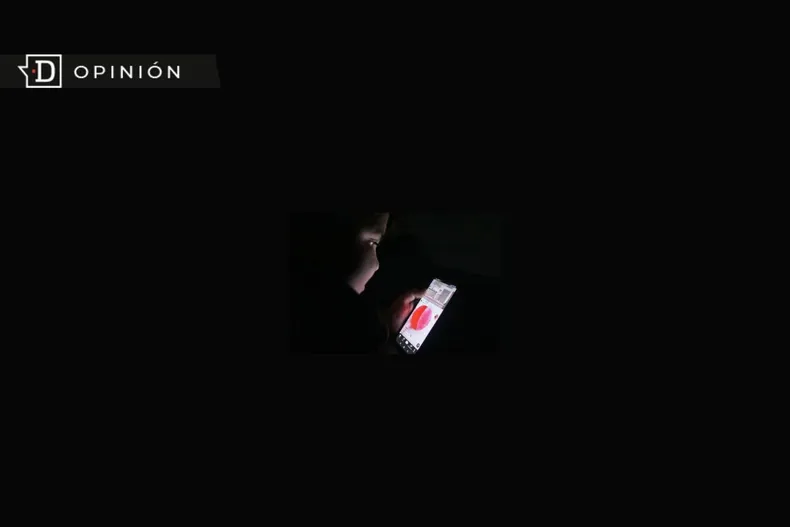25258 nino viendo un celular con un fondo negro.webp