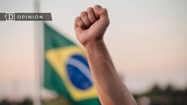 El Desconcierto | 5734 una mano alzada y de fondo la bandera de brasil.jpg