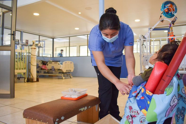 Imagen de una profesional de la salud junto a un niño en CONIN / Foto: CONIN.cl