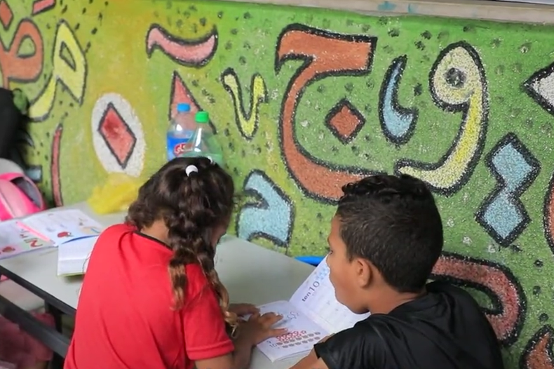 ninos y ninas en escuela en Gaza transformada en refugio.png