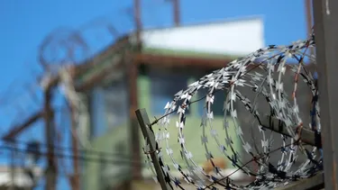 El Desconcierto | Imagen de un alambre de púas en el muro de una cárcel