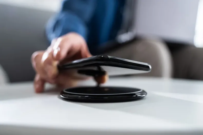 26387 persona pone un smartphone en un cargador inalambrico.webp