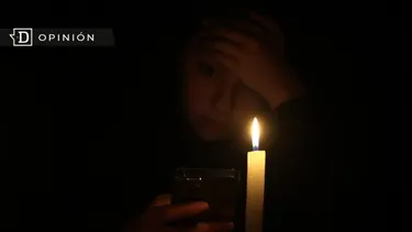 El Desconcierto | 12196 imagen de una mujer mirando un celular con luz de vela duran.webp