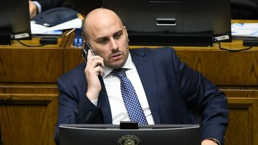 El senador Andrés Longton habla por teléfono durante la sesión en sala del Senado - Agencia Uno