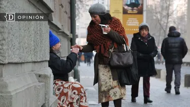 El Desconcierto | 25068 una senora dandole algo a una persona en situacion de calle.webp