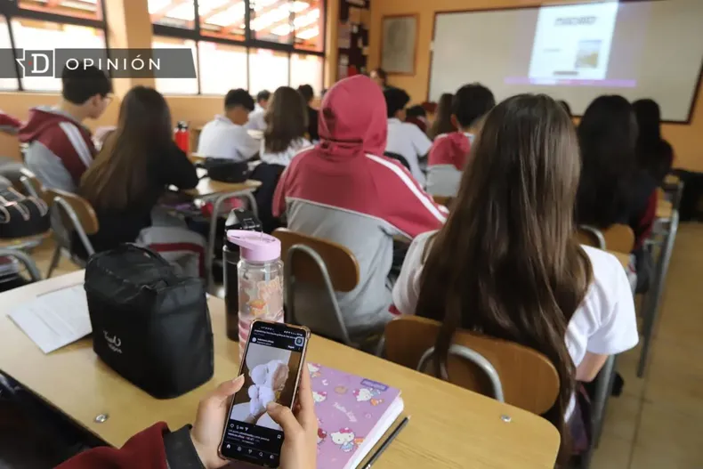 29356 un estudiante con su celular en la sala de clases.webp