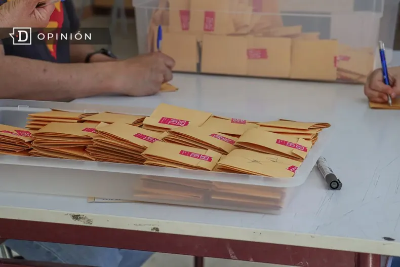 18137 fotos de votos con logo del servel en una mesa.webp