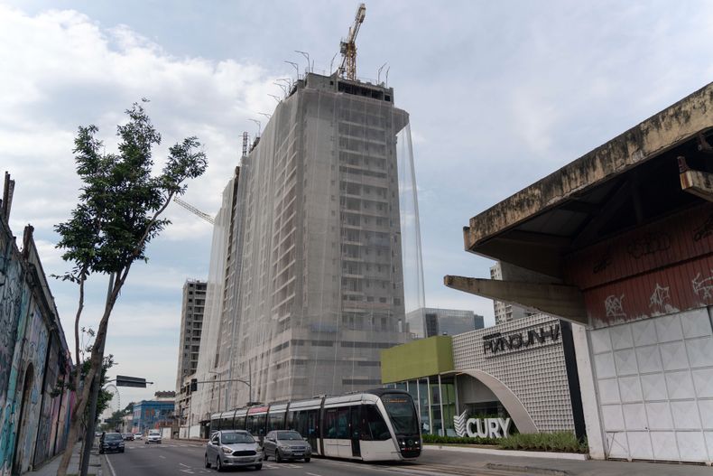 Emprendimiento inmobiliario de la constructora CURY en la Región Portuaria de Río de Janeiro, área que concentra una de las mayores transformaciones urbanas recientes de la ciudad. Solo en los últimos años, miles de nuevas unidades residenciales fueron aprobadas en la zona portuaria, principalmente destinadas a sectores medios y de inversión. El contraste entre la verticalización acelerada y la precariedad habitacional evidencia la desigualdad estructural en el acceso a la vivienda en Brasil. Región Portuaria, Río de Janeiro, Brasil.