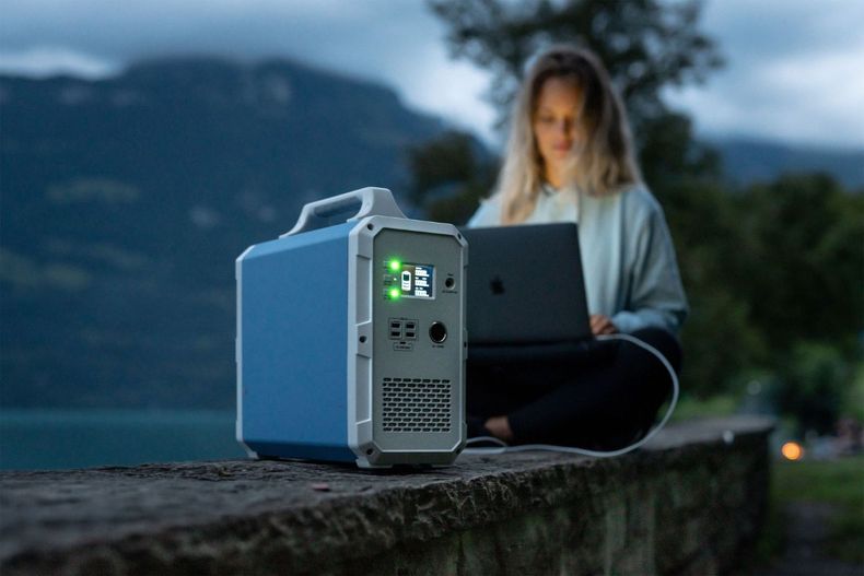 Mujer utiliza energía solar para cargar su computador.