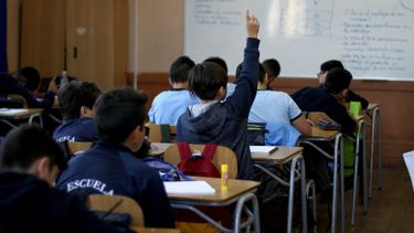 Imagen de un estudiante levantando la mano en una sala de clases / Agencia Uno