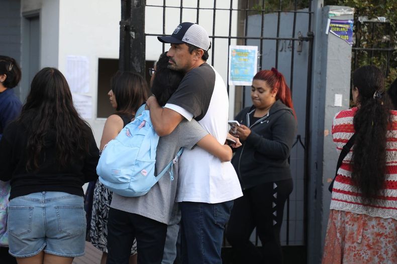 Padre abrazando a su hija a la entrada de un colegio / Agencia Uno