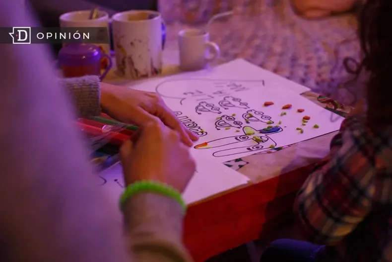 15102 manos de una madre y las de su hija pintando en una mesa.webp