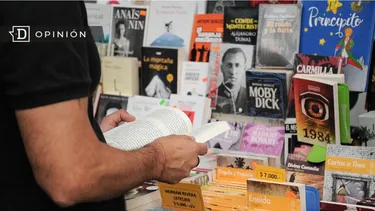 El Desconcierto | 16009 hombre leyendo un libro frente a un stand con mas libros.webp