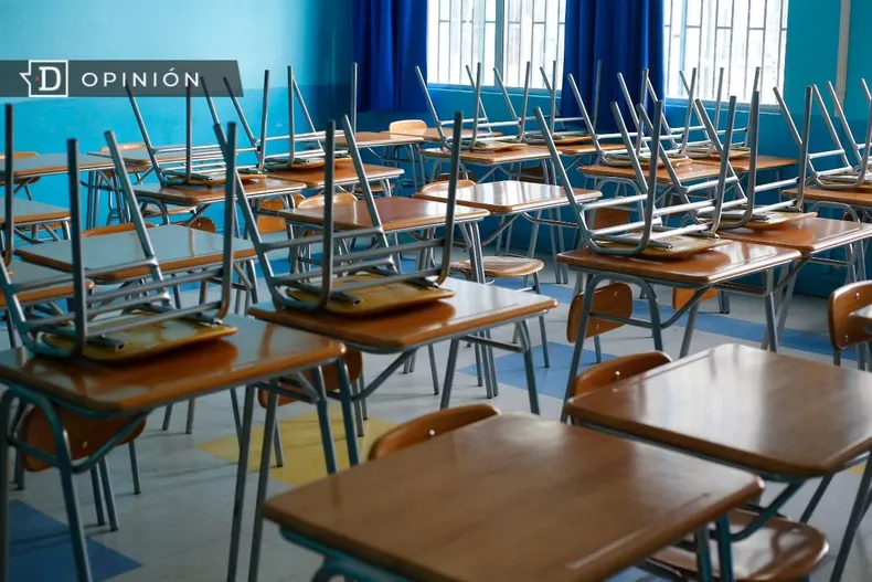 11090 sala de clases vacia con las sillas arriba de las mesas.webp