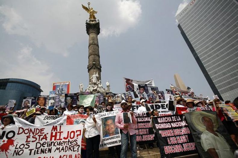 2013_Mexico_ProtestersHoldPlacardsAndPhotographsOfDisappearedRelateivesinMexicoCity_0.jpg