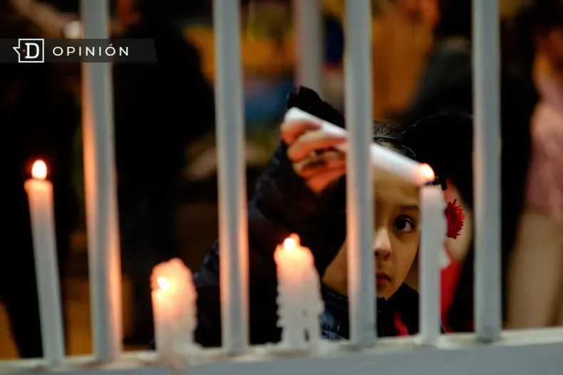22439 nina prendiento unas velas en una reja.webp