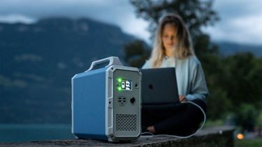 Mujer utiliza energía solar para cargar su computador.