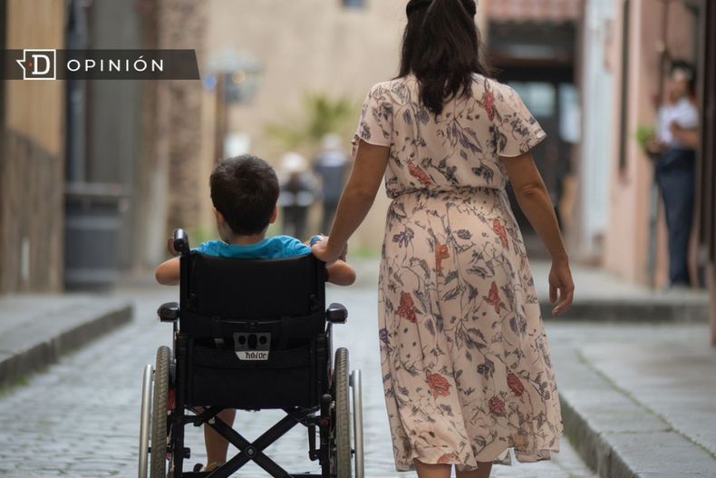 7295 mujer caminando junto a un nino en silla de ruedas.jpg