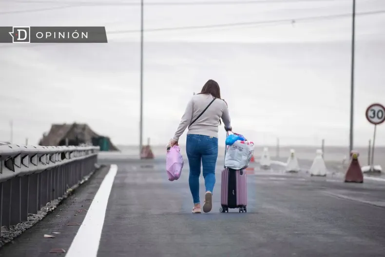28579 mujer caminando en la frontera con una maleta.webp
