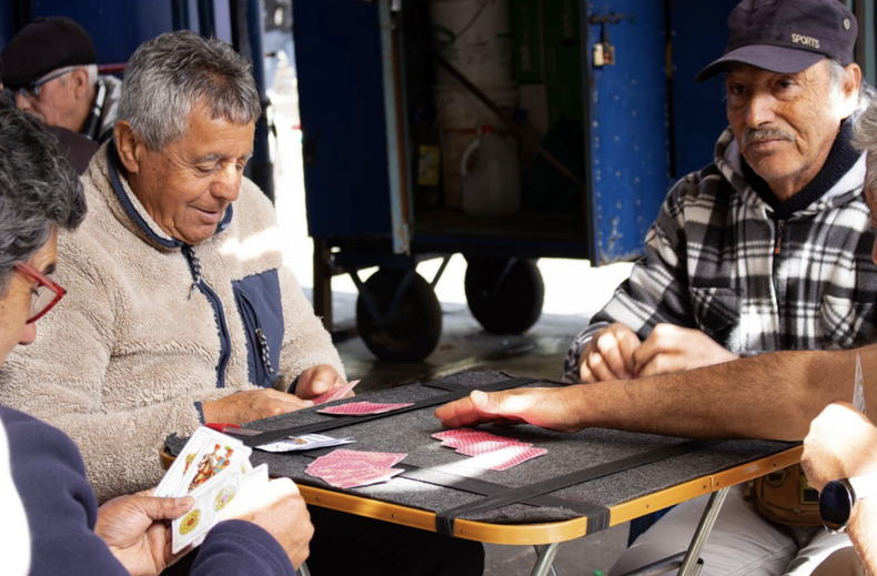 Jugadores de Valparaíso: Integrantes del Club de Brisca de la Tercera Edad se reúnen en el espacio público para compartir un juego que los mantiene conectados con su comunidad.