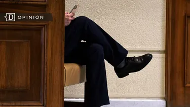 El Desconcierto | 29452 un hombre de traje sentado viendo un celular.webp