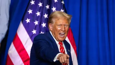 Imagen de Donald Trump apuntando al frente con una bandera de Estados Unidos detrás de él