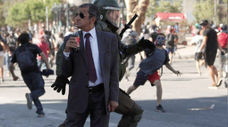 La historia de la foto en la que aparece un hombre bebiendo una gaseosa y un carabinero que corre detrás